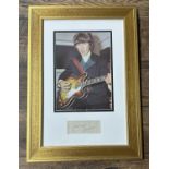 George Harrison - autographed display, mounted below a picture of George Harrison playing an