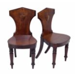 Pair of Victorian mahogany hall chairs, each with a moulded shield to the shaped back, raised on