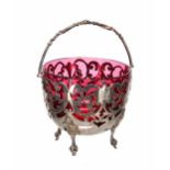 Victorian silver bonbon basket with a cranberry glass liner, with a swing handle over the foliate