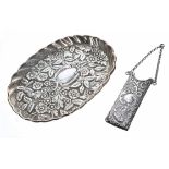 Victorian repoussé silver comb case on chain, with foliate and scroll decoration, contains a