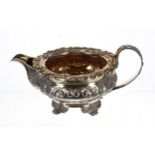 George IV silver cream jug, with a wide flared scrolling cast rim and handle, over a repousse