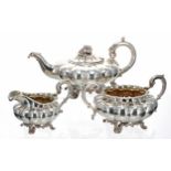 William IV three piece silver tea set, each with C scroll capped handles, the teapot with ivory