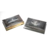 Two similar Thai white metal cigarette boxes, with Niello type decorated covers with buildings and a