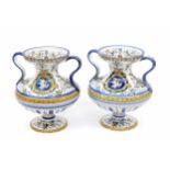 Pair of French Gien faience ware vases, with twin-handles, decorated with cherubs in scroll