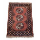 Small Bokhara type rug, on a red ground decorated with three medallions within a wide geometric