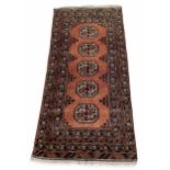 Bokhara pattern rug, decorated with five medallions woithin multiple repeated geometric borders on a