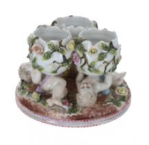 Sitzendorf porcelain centrepiece, modelled as three broken eggs supported by three cherub figures,