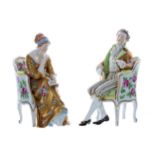Pair of Dresden Potschappel porcelain figures, modelled as a lady in a gold dress seated on a floral