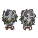 Pair of Sitzendorf porcelain ovoid vases, modelled as eggs with cherub figures to the interior,