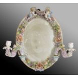 Sitzendorf porcelain twin-branch oval wall mirror, the frame encrusted with flowers, surmounted by