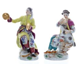Two Meissen porcelain figures, a lady with cymbals and a lady with her dog on her lap, both