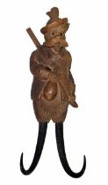 Novelty Black Forest musical coat hook carved as a dog in hunting apparel and rifle strapped over