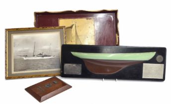 Painted wooden half hull model of a yacht, mounted bearing multiple plaque accolades for 'Winner