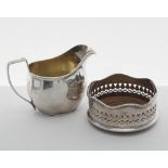 George V silver cream jug, of helmet shape cast with a textured border and the interior gilt,