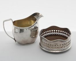 George V silver cream jug, of helmet shape cast with a textured border and the interior gilt,