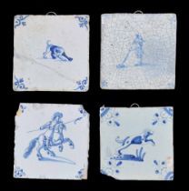 Group of four Dutch Delft pottery tiles, decorated in blue on white with dogs, soldier on