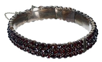 Garnet set gilt bangle with safety chain, 27.4gm; with a 9ct garnet pendant on a slender chain, 2.
