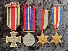 A German WW1 Iron Cross, together with three WWII medals.