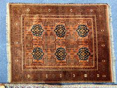 An Aztec Design Afghan Mahamadi Wool Rug, in shades of rust, brown and black, with fringed edges.