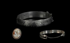 A Hinged Silver Bangle, together with a silver framed shell cameo.
