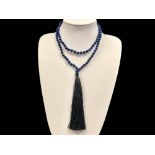 A Lapis Lazuli Bead Necklace with black tassel trim.