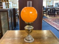 Brass Oil Lamp with orange glass shade and interior chimney. In good condition.