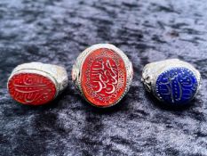 Three Unusual Stone Set White Metal Rings, two set with cornelian, one of which is engraved with