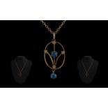 9ct Gold Edwardian Pendant, set with blue stones, suspended on a link chain.