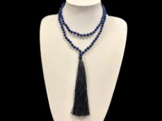 A Lapis Lazuli Bead Necklace with black tassel trim.