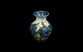 W. Moorcroft Small Vase. Blue & White Background with Blue Flowers and Green Stems. Approx 4