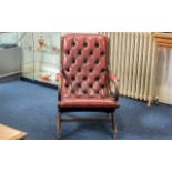 A Leather Chesterfield Armchair in ox blood leather and button back and seat.