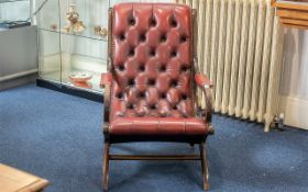 A Leather Chesterfield Armchair in ox blood leather and button back and seat.