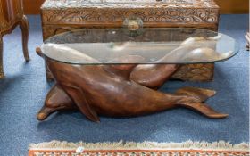 Carved Wood Dolphin Table, depicting two dolphins cascading through the ocean. Glass topped.