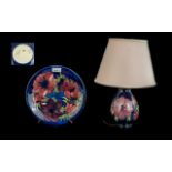 Two Moorcroft Pieces, comprising a Table Lamp & Plate, Hibiscus pattern on a blue ground,
