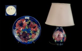 Two Moorcroft Pieces, comprising a Table Lamp & Plate, Hibiscus pattern on a blue ground,