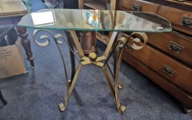 Glass Topped Conservatory Table, raised on four ornate metal legs in brushed bronze.