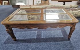 A Modern Walnut Coffee Table of Rectangular Form, four glass panels to the top, carved and shaped