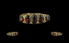 18ct Gold Garnet & Diamond Ring, five graduating garnets with diamond spacers, fully hallmarked