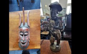 Two Wooden African Carvings, comprising a large African man holding a fish, measures 26'' high.