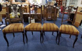 Four Early 20th Century Dining Chairs, with carved backrests depicting torches, stuffed seats,
