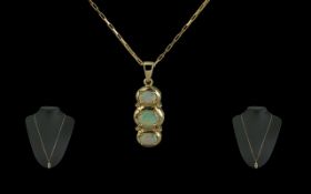 A Fine 9ct Gold Opal Set Pendant, set with a trio of opals of good colour. Attached to a long 9ct