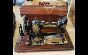 Vintage Jones Sewing Machine, black and gold design, housed in a wooden case with key.