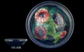 Moorcroft Footed Bowl, 6.5'' diameter, Anenome pattern, pink and mauve flowers on dark blue base. In