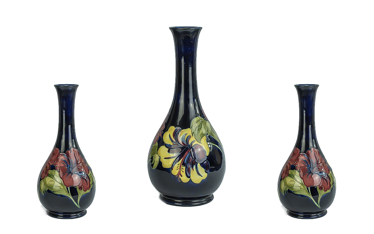 Moorcroft Tall Tube lined Bulbous Vase with Long Stem. ' Hibiscus ' Variation Design on Blue Ground,