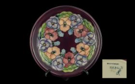 Moorcroft Purple Ground Plate, decorated with Pansies, measures 10'' diameter. Marked Moorcroft to