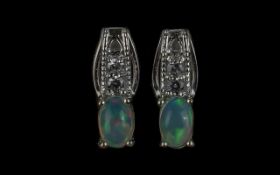 Opal Drop Stud Earrings, each comprising an oval cut opal set below two round cut, sparkling,