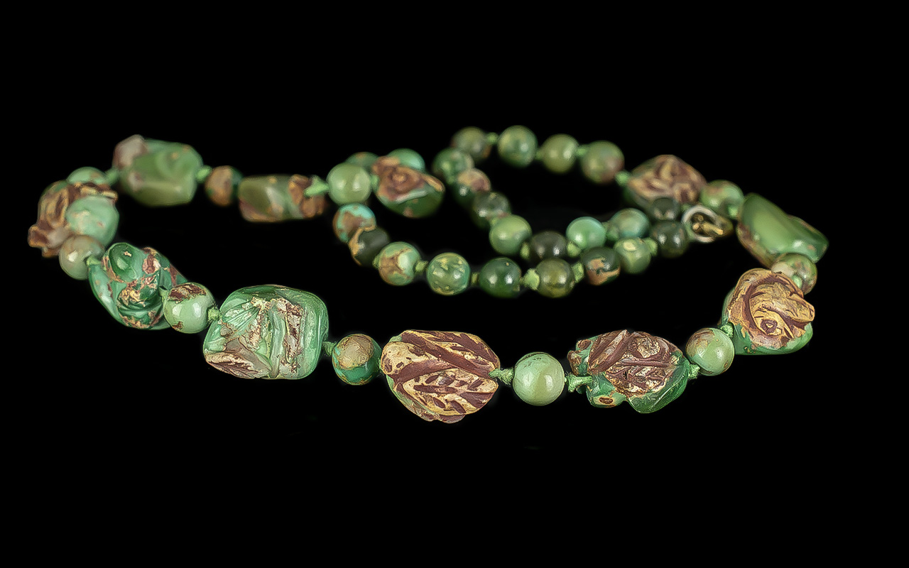 Green Opal and Carved Stone Necklace, the irregular green opal beads have retained areas of the
