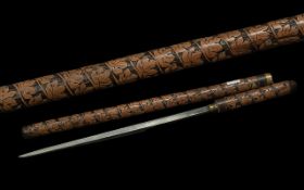 Early 20th Century Sword Stick / Baton with highly carved decoration and brass mount; 21 inches (