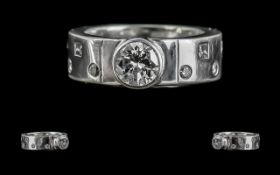 Platinum Diamond Set Band Ring, Marked to Shank. The Central Round Brilliant Cut Diamond, Flanked by
