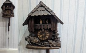 Wooden Carved Cuckoo Clock, with carvings of horses pulling logs, brass Roman numerals, pendulums,